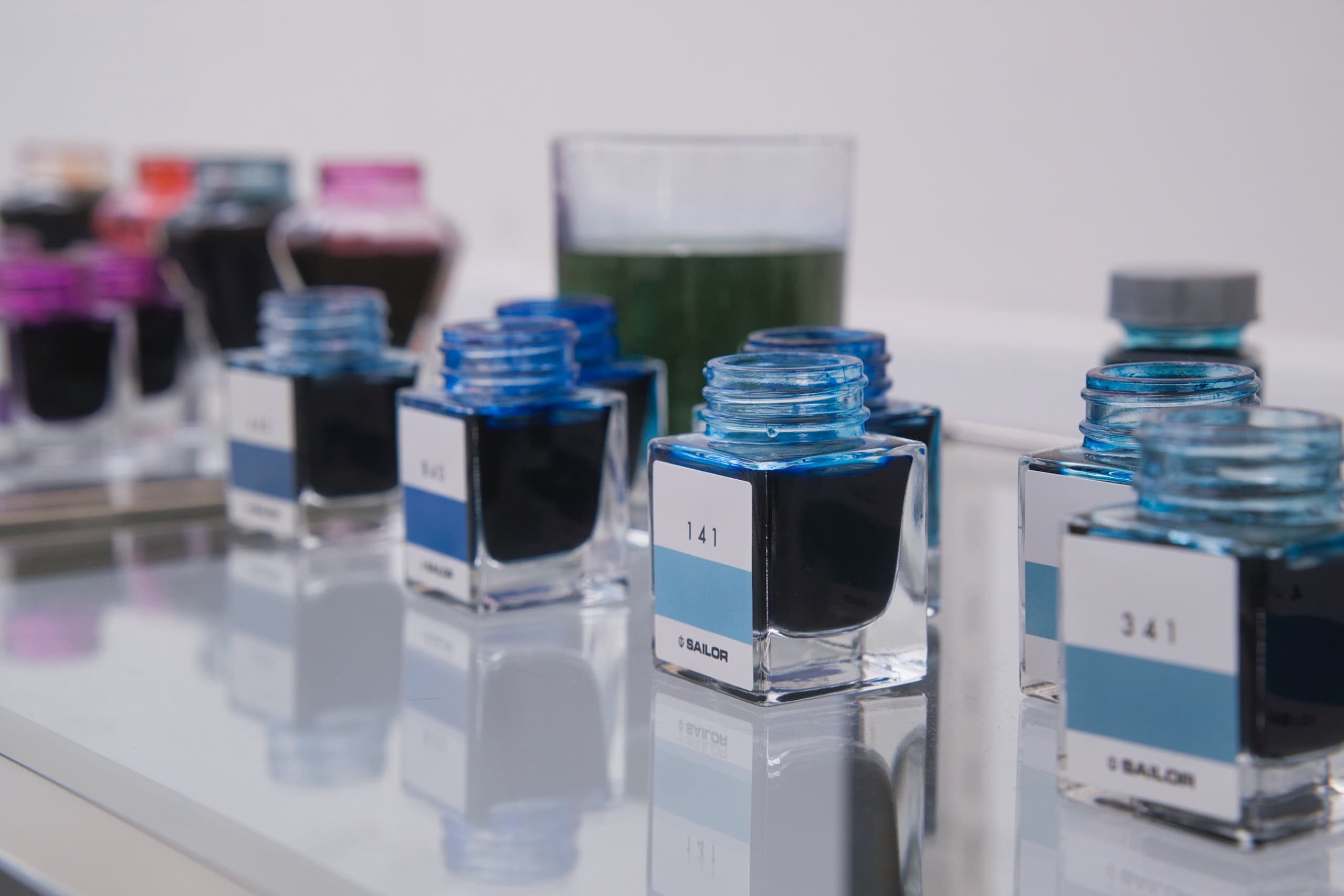 ガラスの瓶に入った青いインクが並ぶ。