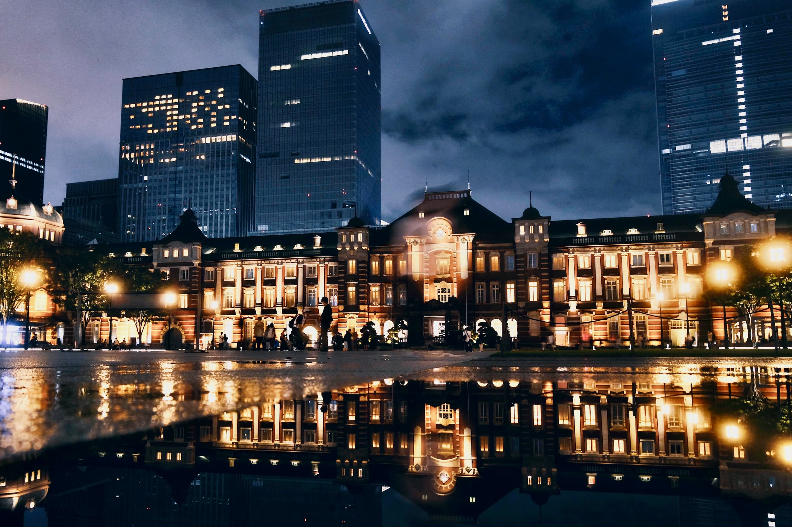 夜の東京駅と高層ビル、雨上がりの反射。