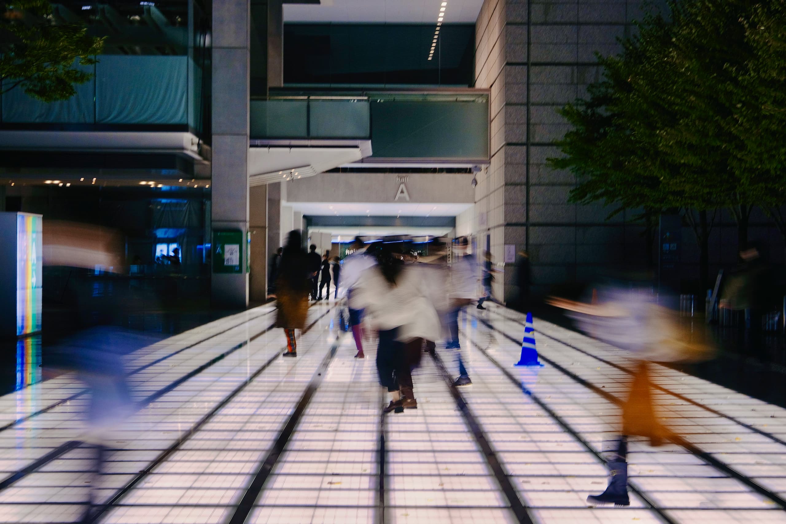 夜の東京国際フォーラムのアトリウムを歩く人々。